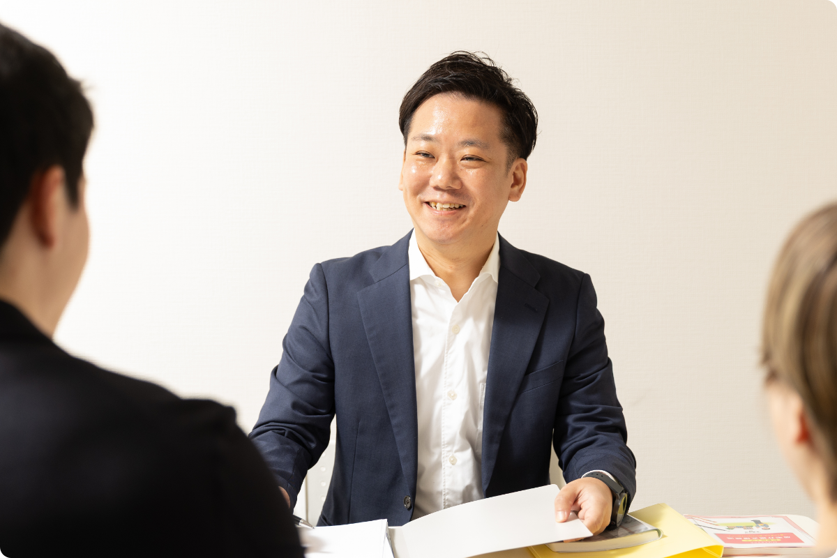 対面で和やかに会話をしているスーツ姿の男性スタッフ