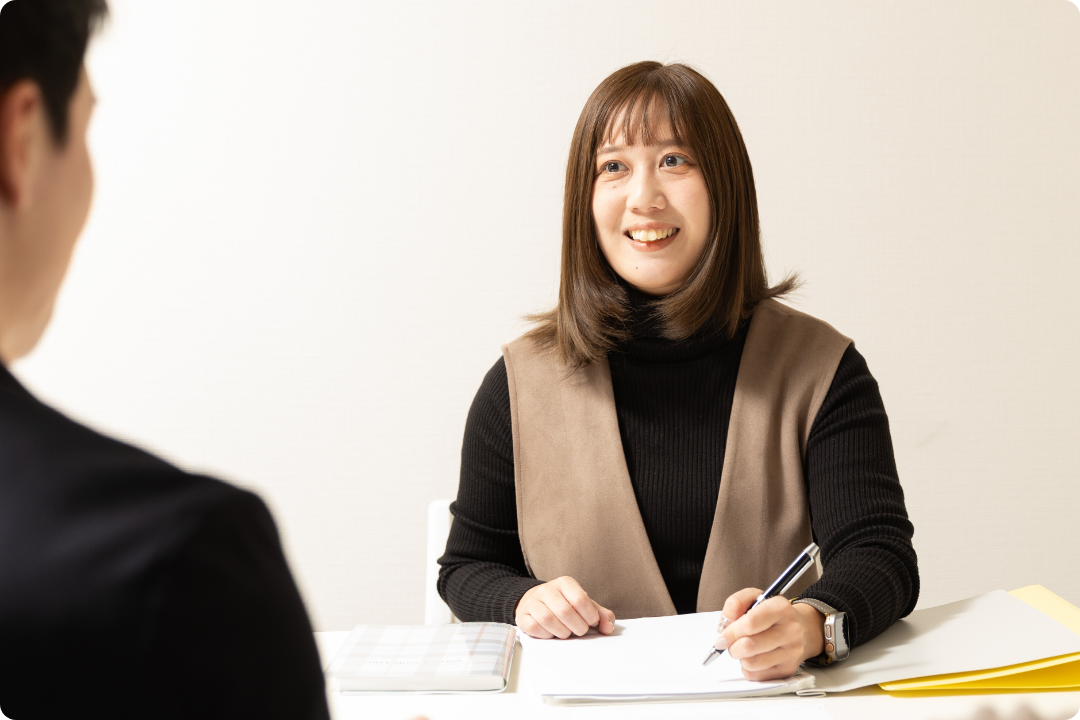 和やかな表情で対面での相談に応じる女性スタッフ
