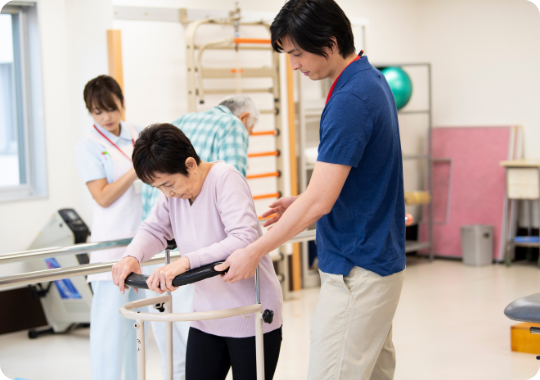 平行棒を使った歩行訓練をサポートしている様子